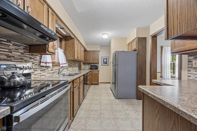 1330 12th St N, Fargo, ND 58102 - kitchen featuring stainless steel appliances, exhaust hood, backsplash, a textured ceiling, and brown cabinets