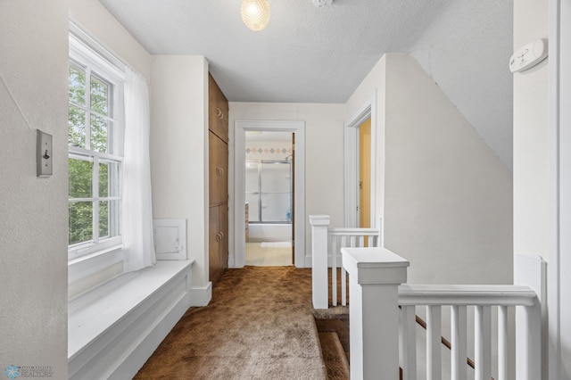 1330 12th St N, Fargo, ND 58102 - hallway featuring an upstairs landing, carpet flooring, plenty of natural light, and a textured ceiling