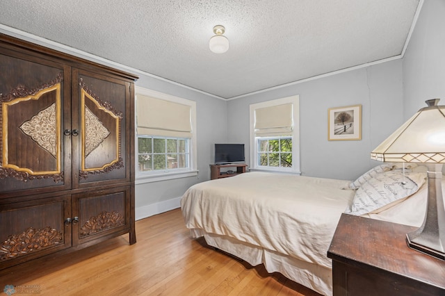 1330 12th St N, Fargo, ND 58102 - bedroom with light wood-style floors, ornamental molding, and a textured ceiling