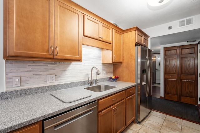 6615 Lake Shore Dr S Unit 803, Richfield, MN 55423 - kitchen with appliances with stainless steel finishes, light tile patterned flooring, decorative backsplash, and brown cabinetry