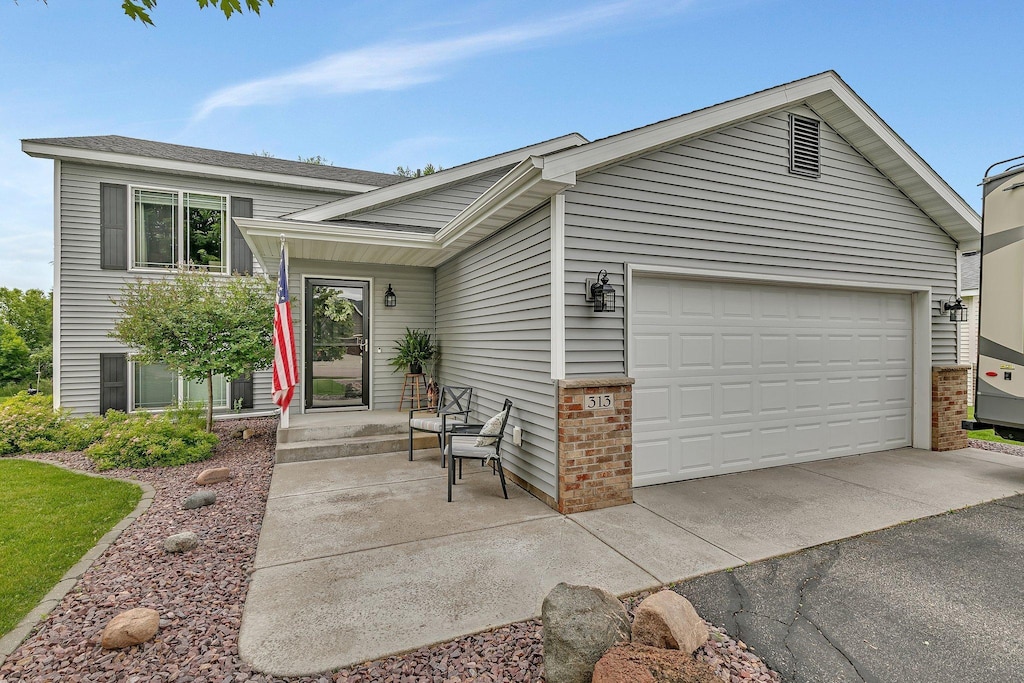313 Victory Ave, Sartell, MN 56377 - tri-level home featuring an attached garage