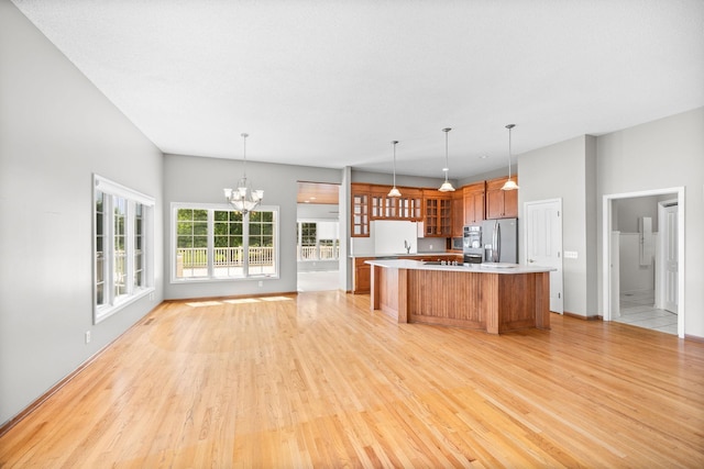 1215 Shore Dr SW, Hutchinson, MN 55350 - kitchen featuring stainless steel fridge, a kitchen island, light wood-style floors, light countertops, and brown cabinets