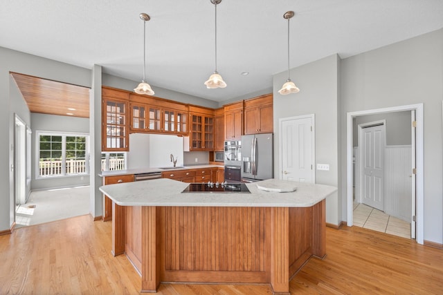 1215 Shore Dr SW, Hutchinson, MN 55350 - kitchen featuring stainless steel appliances, light wood-style flooring, glass insert cabinets, brown cabinetry, and a kitchen island