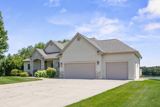 1215 Shore Dr SW, Hutchinson, MN 55350 - view of front facade featuring stucco siding, stone siding, an attached garage, a front lawn, and driveway