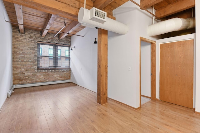 400 1st St Unit 502, Minneapolis, MN 55401 - spare room featuring brick wall, a wood ceiling with exposed beams, wood finished floors, and a baseboard heating unit