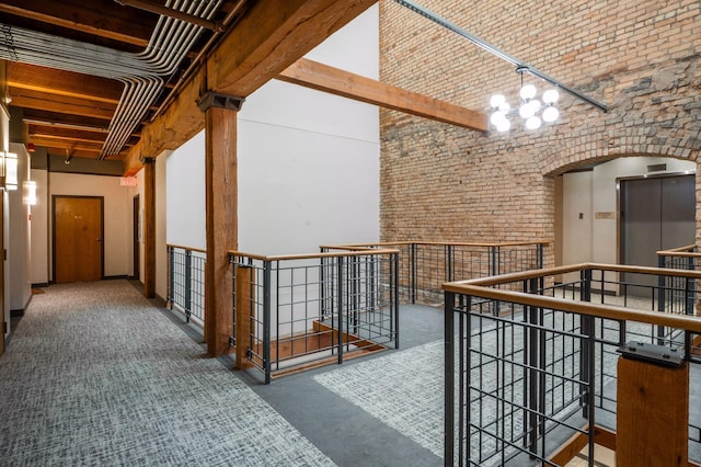 400 1st St Unit 502, Minneapolis, MN 55401 - hallway with an upstairs landing, a chandelier, carpet, a high ceiling, and brick wall