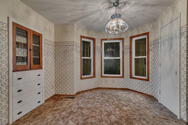 906 Holcombe Ave, Litchfield, MN 55355 - unfurnished dining area featuring wallpapered walls, carpet, a chandelier, and a textured ceiling