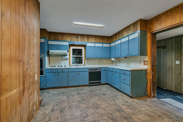 906 Holcombe Ave, Litchfield, MN 55355 - kitchen with black dishwasher, wooden walls, blue cabinetry, under cabinet range hood, and light countertops