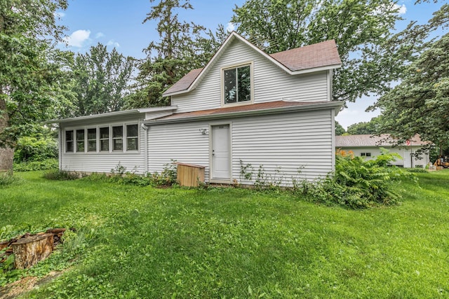906 Holcombe Ave, Litchfield, MN 55355 - rear view of property featuring a lawn and a shingled roof