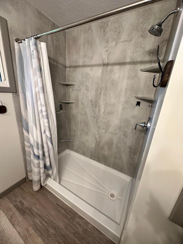 515 2nd St SW, New Richland, MN 56072 - bathroom featuring a shower stall, wood finished floors, and a textured ceiling