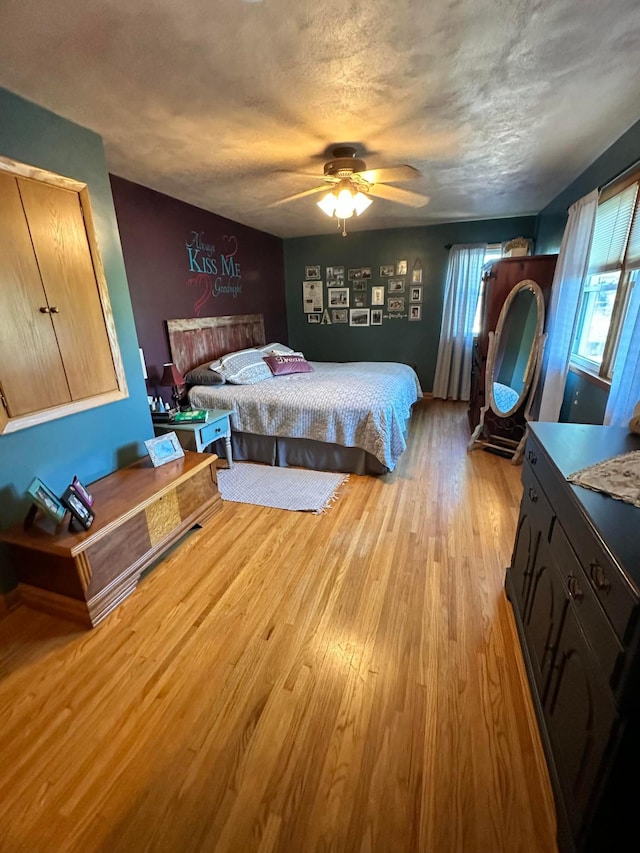 515 2nd St SW, New Richland, MN 56072 - bedroom with light wood-style flooring, a textured ceiling, and ceiling fan
