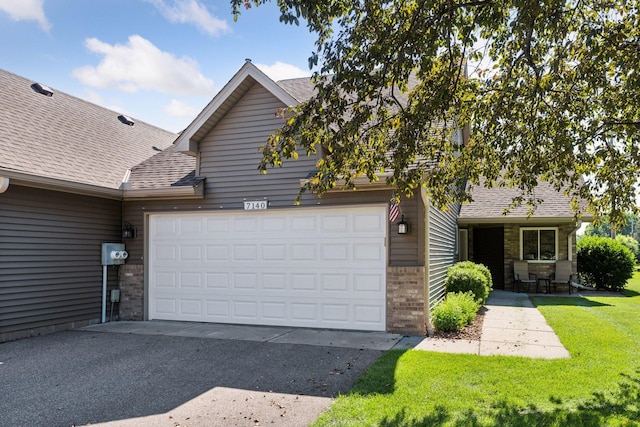 7140 Ivy Ridge Ct, Lino Lakes, MN 55014 - view of front of house featuring brick siding, roof with shingles, a front lawn, and a garage