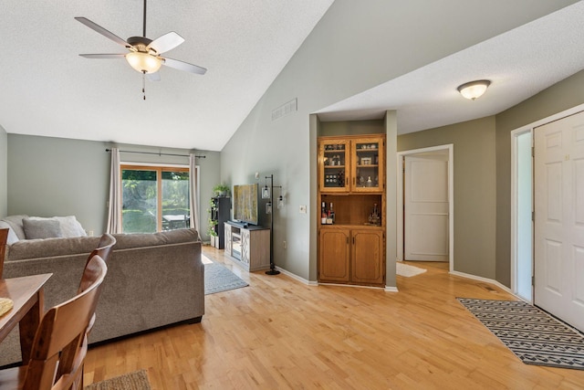 7140 Ivy Ridge Ct, Lino Lakes, MN 55014 - living room with high vaulted ceiling, ceiling fan, light wood-style flooring, and a textured ceiling