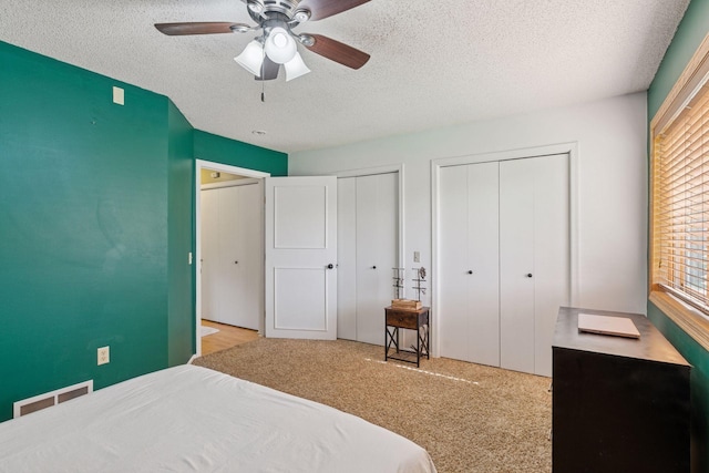 7140 Ivy Ridge Ct, Lino Lakes, MN 55014 - carpeted bedroom with a textured ceiling, two closets, and a ceiling fan