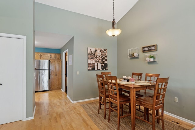 7140 Ivy Ridge Ct, Lino Lakes, MN 55014 - dining area featuring light wood finished floors and high vaulted ceiling
