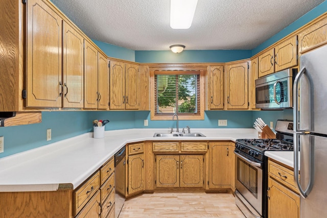 7140 Ivy Ridge Ct, Lino Lakes, MN 55014 - kitchen with appliances with stainless steel finishes, a textured ceiling, light wood-type flooring, light countertops, and brown cabinetry