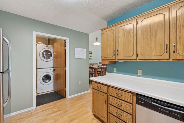 7140 Ivy Ridge Ct, Lino Lakes, MN 55014 - kitchen featuring appliances with stainless steel finishes, stacked washer / drying machine, light wood-style flooring, light countertops, and a textured ceiling