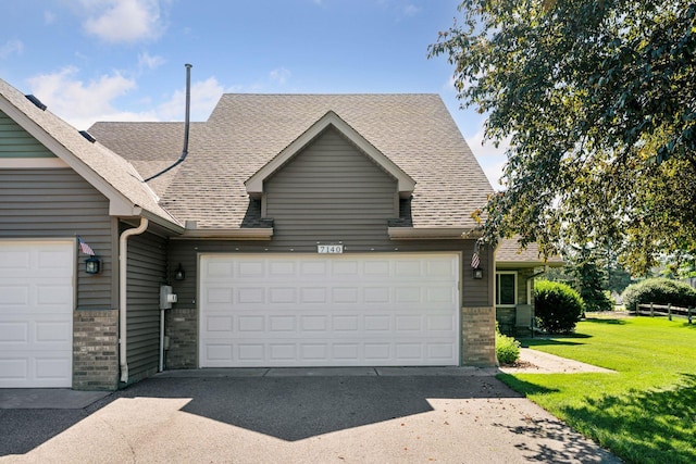 7140 Ivy Ridge Ct, Lino Lakes, MN 55014 - view of front of home with brick siding, a front lawn, a garage, concrete driveway, and a shingled roof