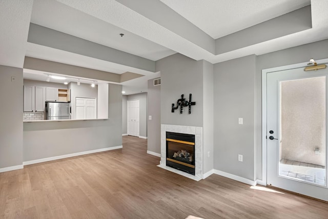 645 1st St Unit 305, Minneapolis, MN 55401 - unfurnished living room with wood finished floors and a tile fireplace