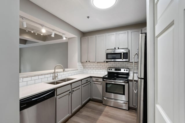 645 1st St Unit 305, Minneapolis, MN 55401 - kitchen with gray cabinets, appliances with stainless steel finishes, tasteful backsplash, and light wood-style floors