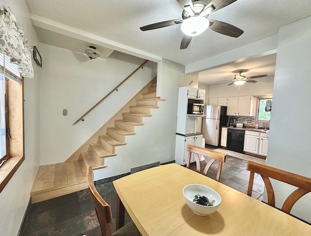 511 3rd St, Nashwauk, MN 55769 - dining space featuring ceiling fan, stairway, stone tile floors, and a textured ceiling