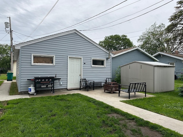 511 3rd St, Nashwauk, MN 55769 - back of property with a lawn, a fire pit, a patio area, and a storage unit
