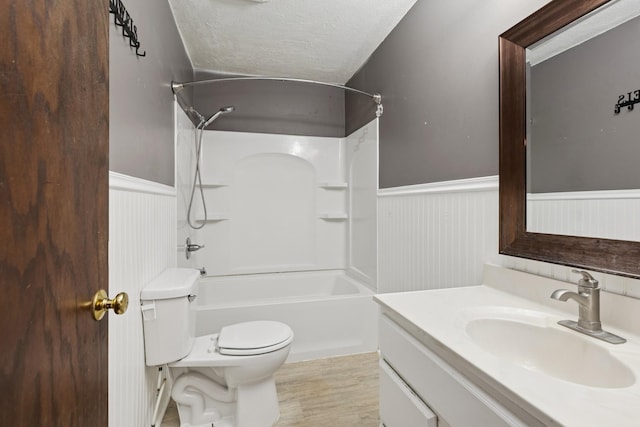 812 Ivanhoe Dr, Northfield, MN 55057 - bathroom featuring wainscoting, a textured ceiling, vanity, shower / washtub combination, and wood finished floors