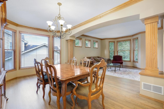 7569 Blackoaks Ln N, Maple Grove, MN 55311 - dining area featuring ornate columns, light wood-style flooring, crown molding, a chandelier, and arched walkways
