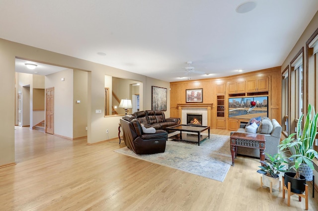 7569 Blackoaks Ln N, Maple Grove, MN 55311 - living area with light wood-style floors, a ceiling fan, a tile fireplace, and stairs