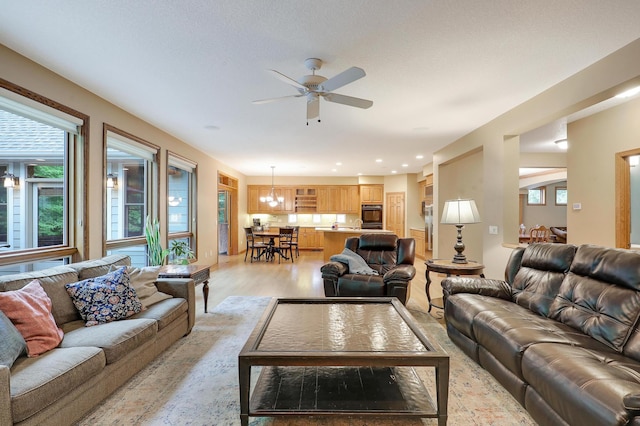 7569 Blackoaks Ln N, Maple Grove, MN 55311 - living area with light wood-style flooring, a ceiling fan, a chandelier, and recessed lighting