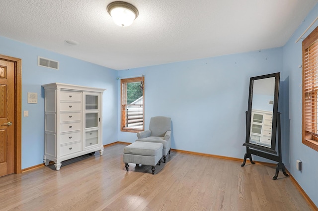 7569 Blackoaks Ln N, Maple Grove, MN 55311 - sitting room featuring light wood-style flooring and a textured ceiling