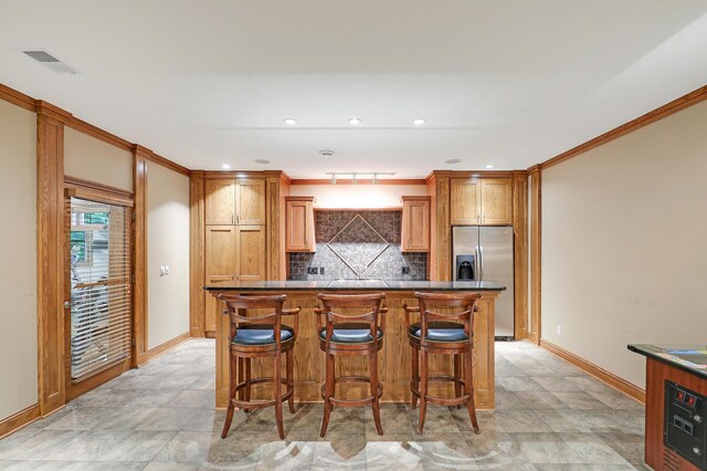 7569 Blackoaks Ln N, Maple Grove, MN 55311 - kitchen with stainless steel fridge, decorative backsplash, crown molding, a kitchen island, and dark countertops