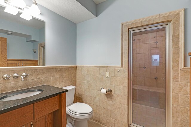 7569 Blackoaks Ln N, Maple Grove, MN 55311 - bathroom featuring tile walls, vanity, a shower stall, and wainscoting