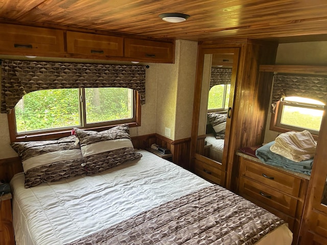 29156 State Highway 47, Aitkin, MN 56431 - bedroom with wooden ceiling, wood walls, and a wainscoted wall