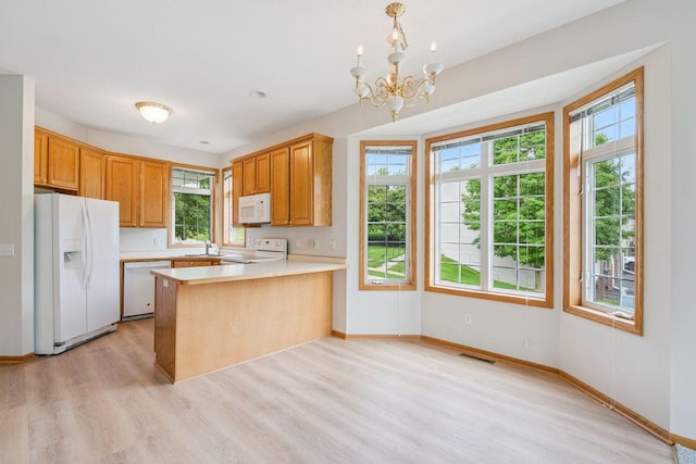 13501 96th Pl N, Maple Grove, MN 55369 - kitchen with white appliances, light wood finished floors, light countertops, a peninsula, and a chandelier