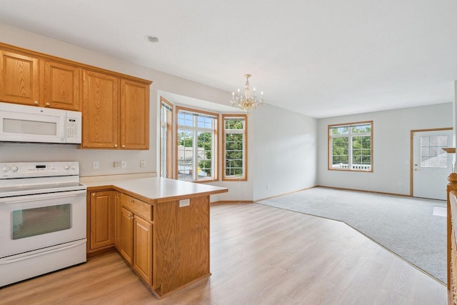 13501 96th Pl N, Maple Grove, MN 55369 - kitchen with white appliances, open floor plan, a chandelier, a peninsula, and light wood-style flooring