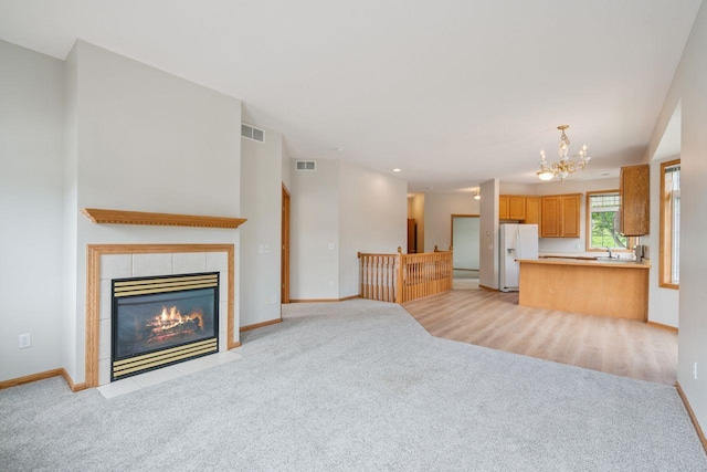 13501 96th Pl N, Maple Grove, MN 55369 - unfurnished living room with light colored carpet, a chandelier, and a fireplace