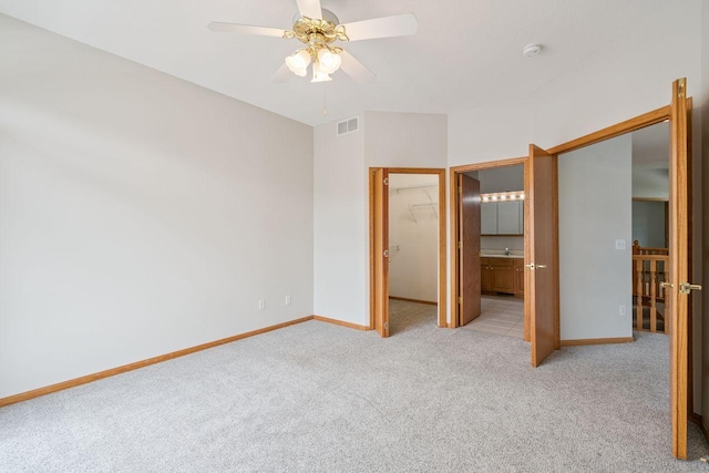 13501 96th Pl N, Maple Grove, MN 55369 - unfurnished bedroom featuring light colored carpet, a spacious closet, ensuite bathroom, a closet, and a ceiling fan