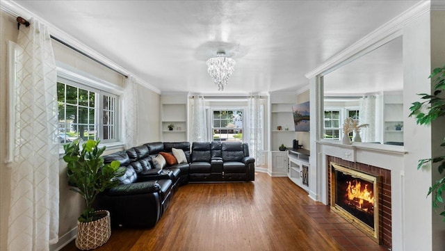 918 Trott Ave SW, Willmar, MN 56201 - living room featuring wood finished floors, a brick fireplace, a chandelier, built in features, and ornamental molding
