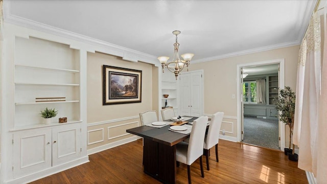 918 Trott Ave SW, Willmar, MN 56201 - dining room with a chandelier, ornamental molding, built in shelves, dark wood-type flooring, and a decorative wall
