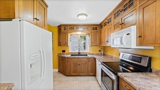 918 Trott Ave SW, Willmar, MN 56201 - kitchen with white appliances, brown cabinetry, glass insert cabinets, light tile patterned flooring, and light countertops