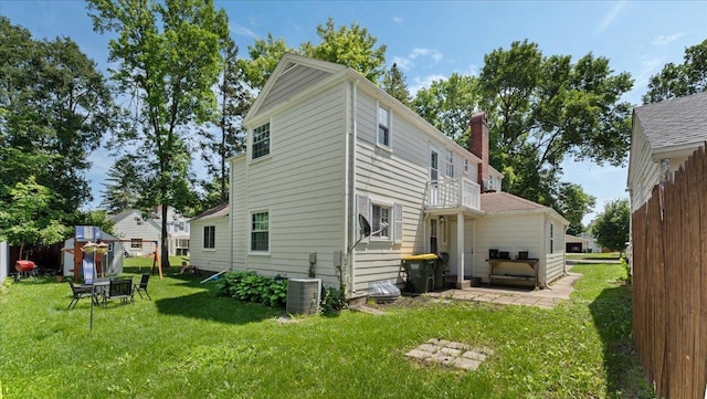 918 Trott Ave SW, Willmar, MN 56201 - back of house featuring a chimney, a lawn, a balcony, and a shed