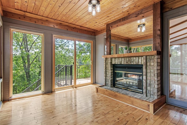 6230 Elm Ridge Cir, Corcoran, MN 55340 - unfurnished living room featuring a glass covered fireplace, wood-type flooring, plenty of natural light, and wood ceiling