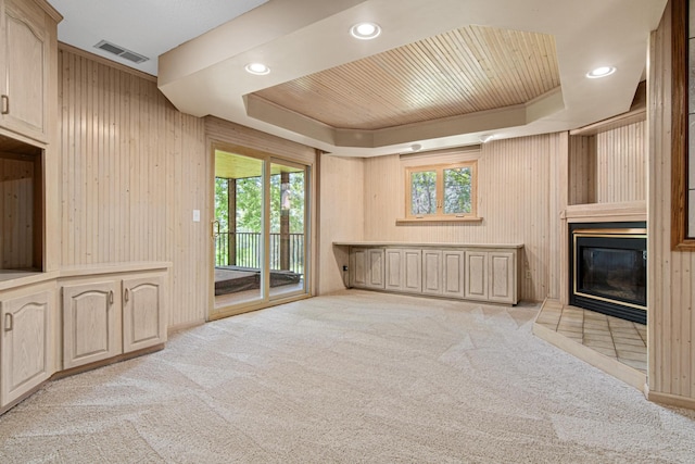 6230 Elm Ridge Cir, Corcoran, MN 55340 - unfurnished living room with a tray ceiling, plenty of natural light, light carpet, wooden walls, and recessed lighting