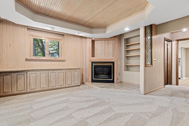 6230 Elm Ridge Cir, Corcoran, MN 55340 - unfurnished living room featuring a glass covered fireplace, carpet, wooden ceiling, built in shelves, and a tray ceiling