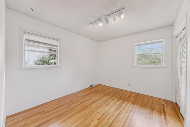 3916 Thomas Ave S, Minneapolis, MN 55410 - unfurnished bedroom with track lighting, light wood-type flooring, a closet, and a textured ceiling