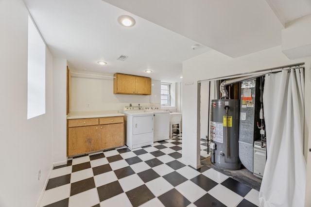 3916 Thomas Ave S, Minneapolis, MN 55410 - kitchen with water heater, tile patterned floors, washer and clothes dryer, light countertops, and brown cabinetry