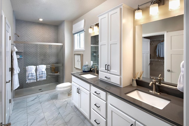 1251 149th St W, Rosemount, MN 55068 - bathroom featuring double vanity, marble finish floors, a stall shower, a textured ceiling, and a walk in closet