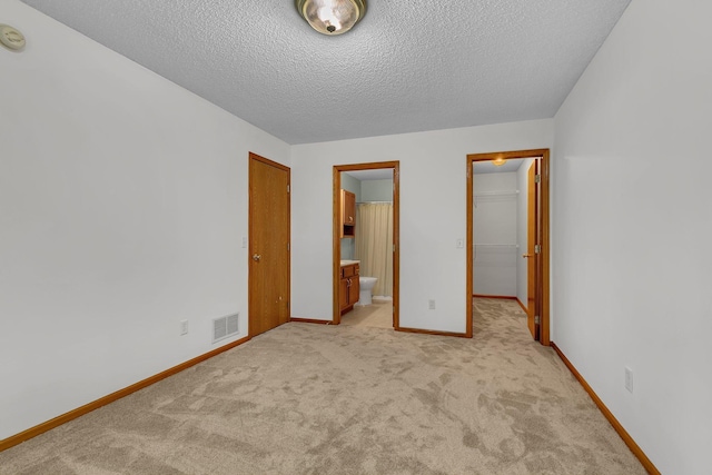 4384 Clearwater Rd, Saint Cloud, MN 56301 - unfurnished bedroom with light colored carpet, a closet, a textured ceiling, a walk in closet, and ensuite bathroom