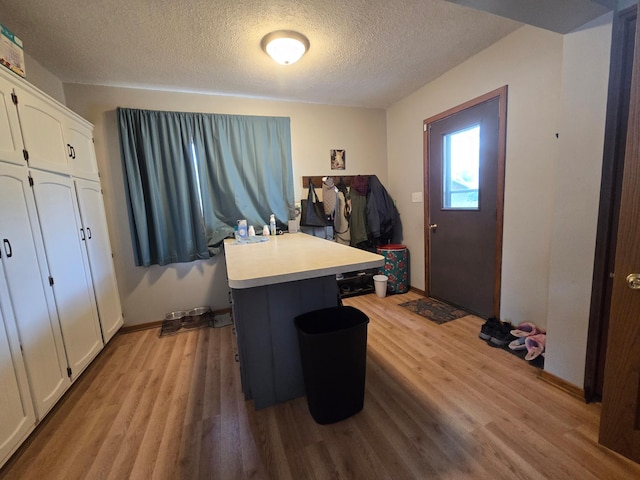 108 9th St, Morris, MN 56267 - laundry room featuring light wood finished floors and a textured ceiling
